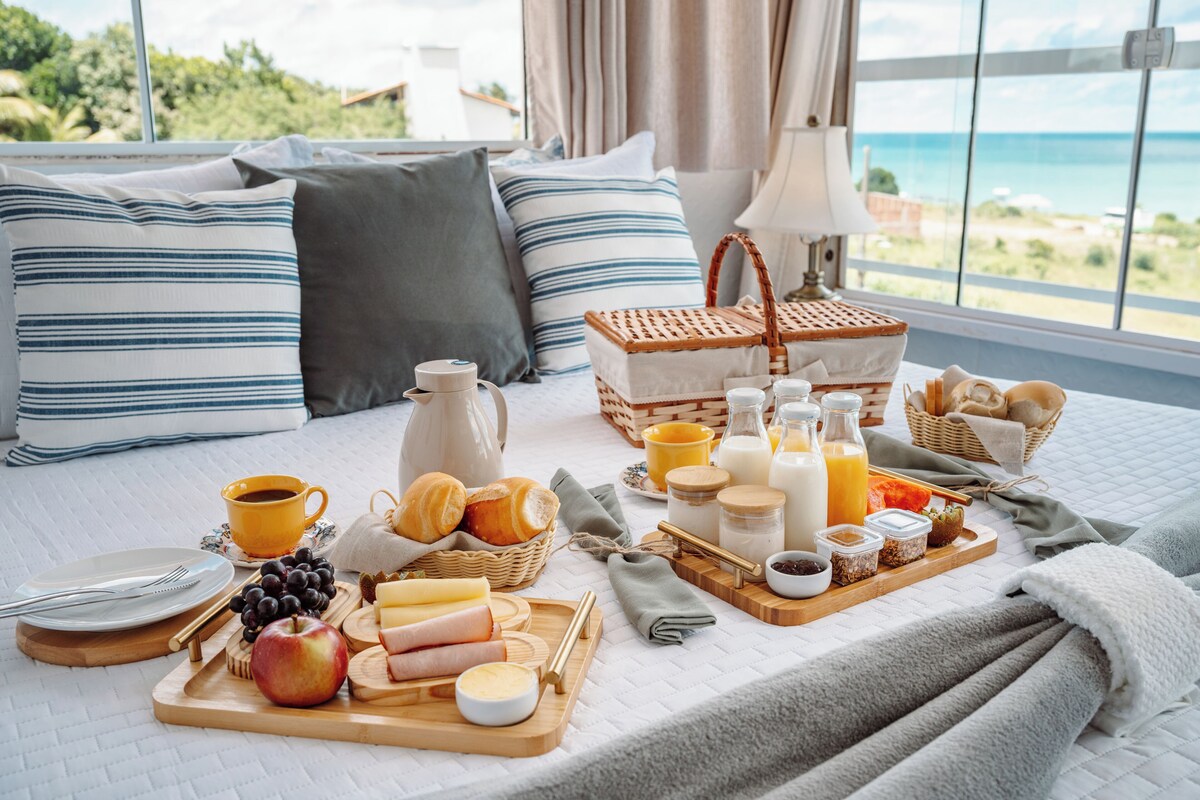 Cesta de café da manhã servida com vista para o mar no Pequeno Paraíso Flats